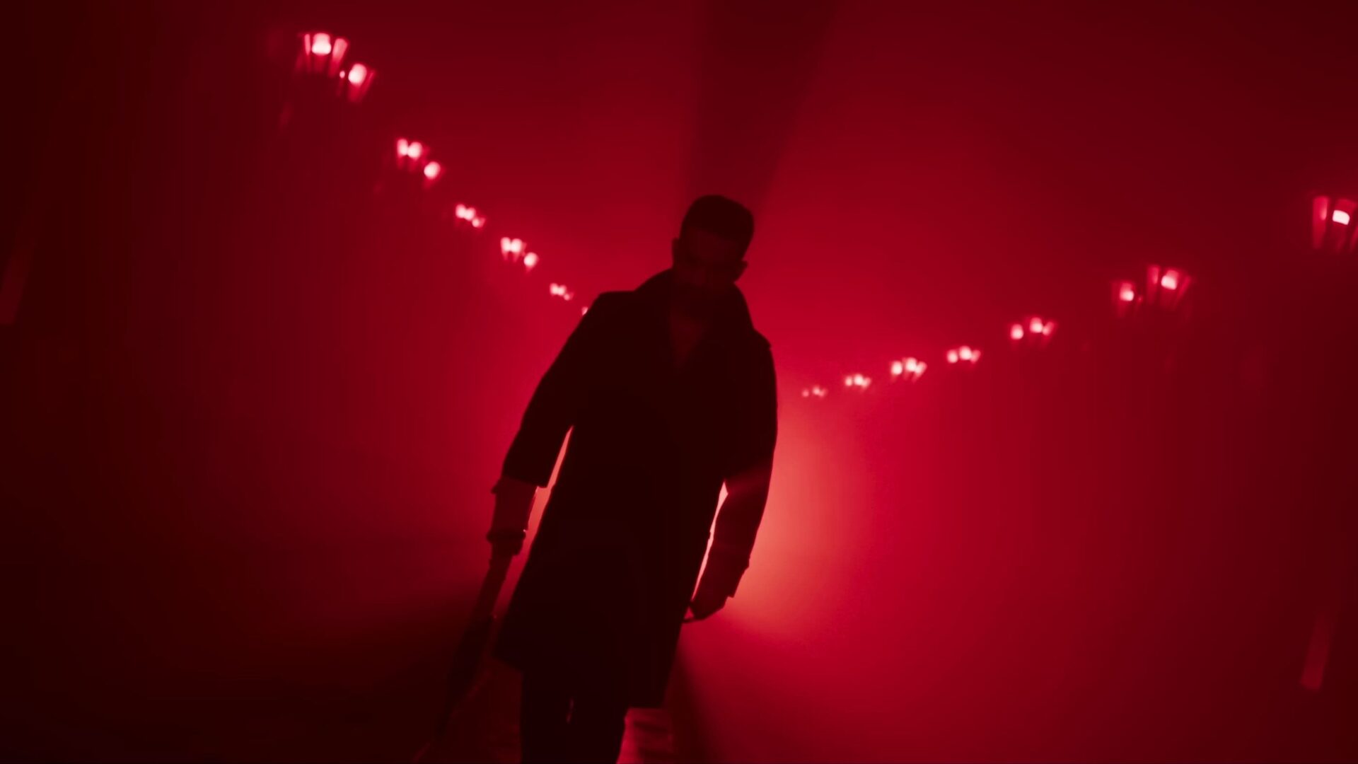 Eine Person in einem Mantel. Im Hintergrund rotes Licht. | War 2 – Filmkritik