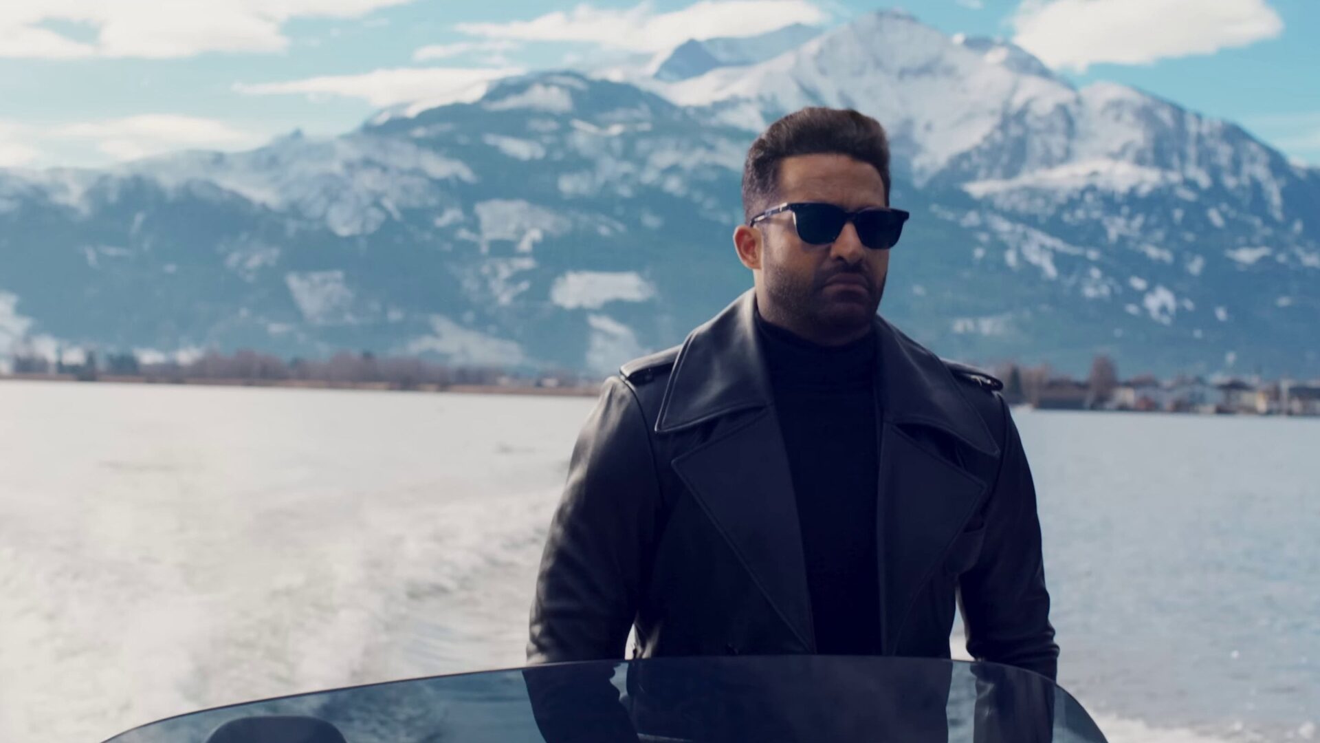 Vikram mit Sonnenbrille und schwarzem Mantel. Im Hintergrund Berge. | War 2 – Filmkritik