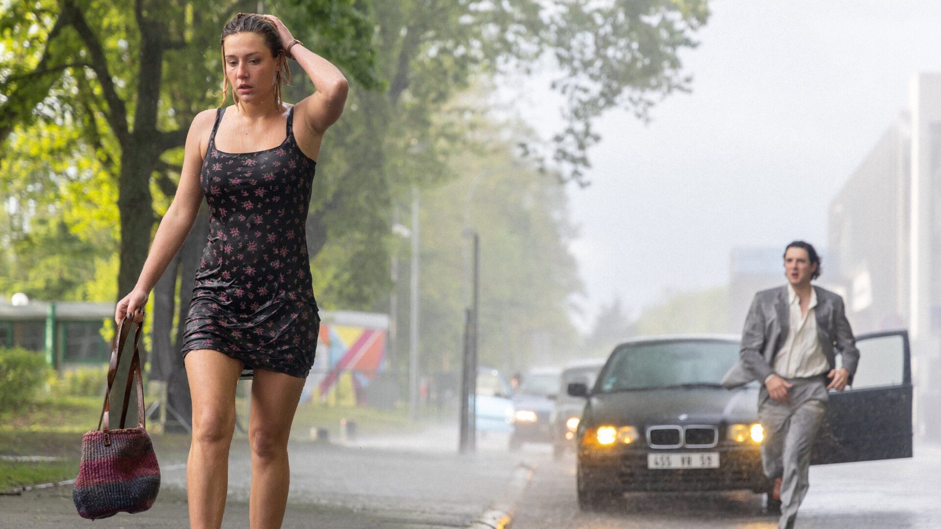 Das Bild zeigt Adèle Exarchopoulos in einer Szene des Films Beating Hearts. Sie läuft durch Regen.