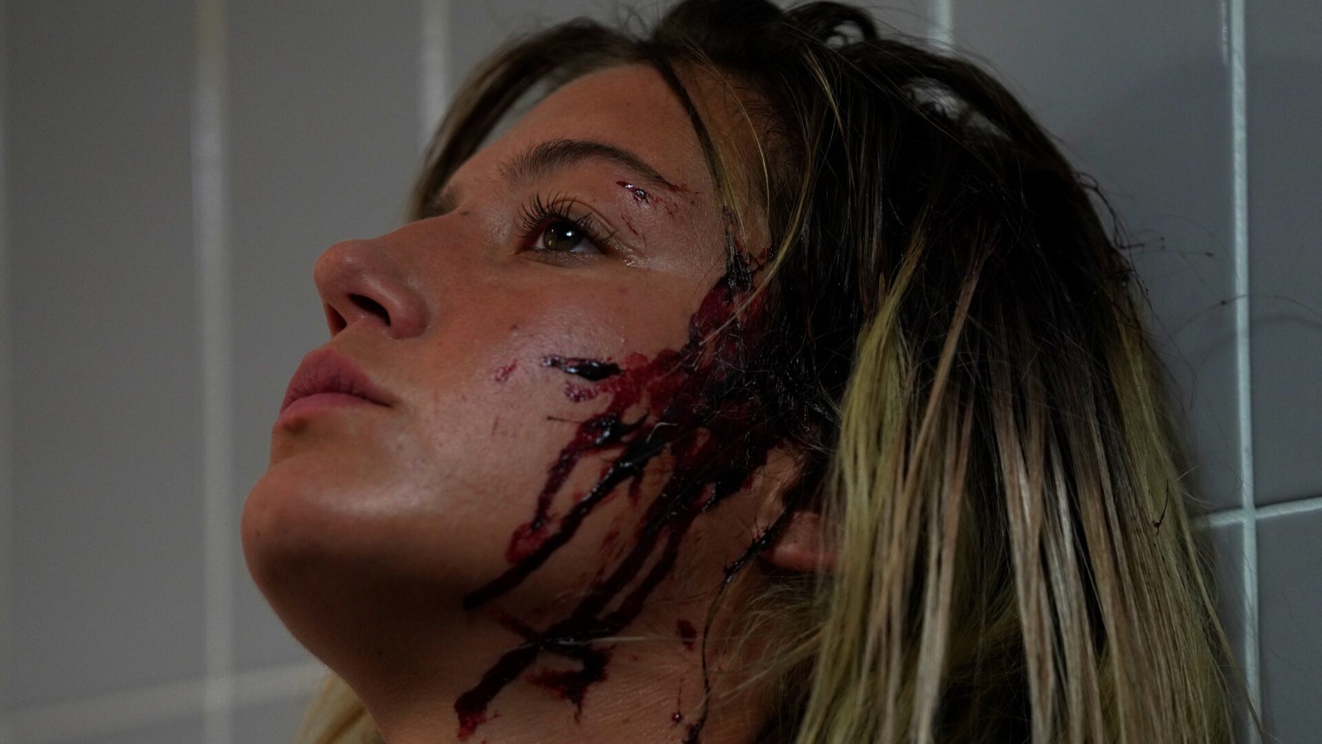 Das Bild zeigt Adèle Exarchopoulos in einer Szene des Films Beating Hearts. Ihr Gesicht ist blutverschmiert.