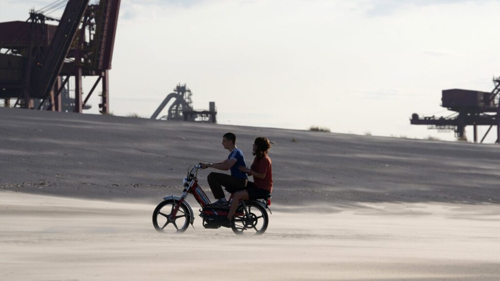 Das Bild zeigt Malik Frikah und Mallory Wanecque in einer Szene des Films Beating Hearts. Sie sitzen auf einem Motorrad.