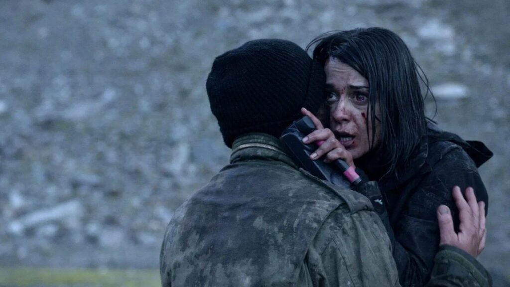Zwei Personen umarmen sich, während die Frau mit blutigem Gesicht erschrocken nach vorne blickt | Die 5 besten deutschen Genrefilme