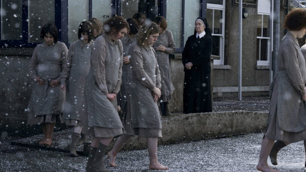 Mehrere junge Frauen betreten bei schneiendem Winter einen Hof. Im Hintergrund steht eine Nonne. Szene aus dem Film Kleine Dinge wie diese.