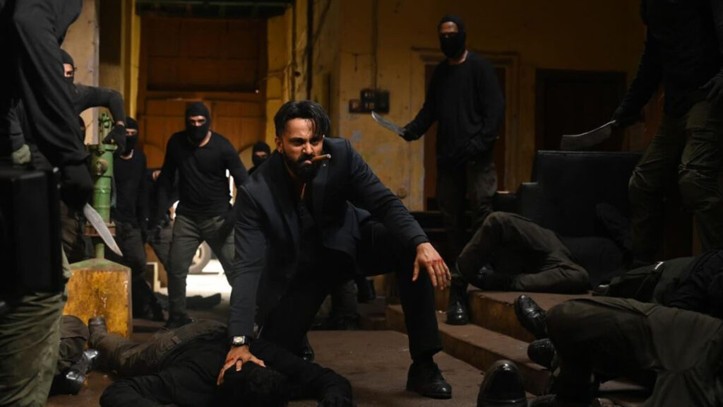 Das Bild zeigt Unni Mukundan in einer Szene des Films Marco. Er kämpft gegen maskierte Gegner.