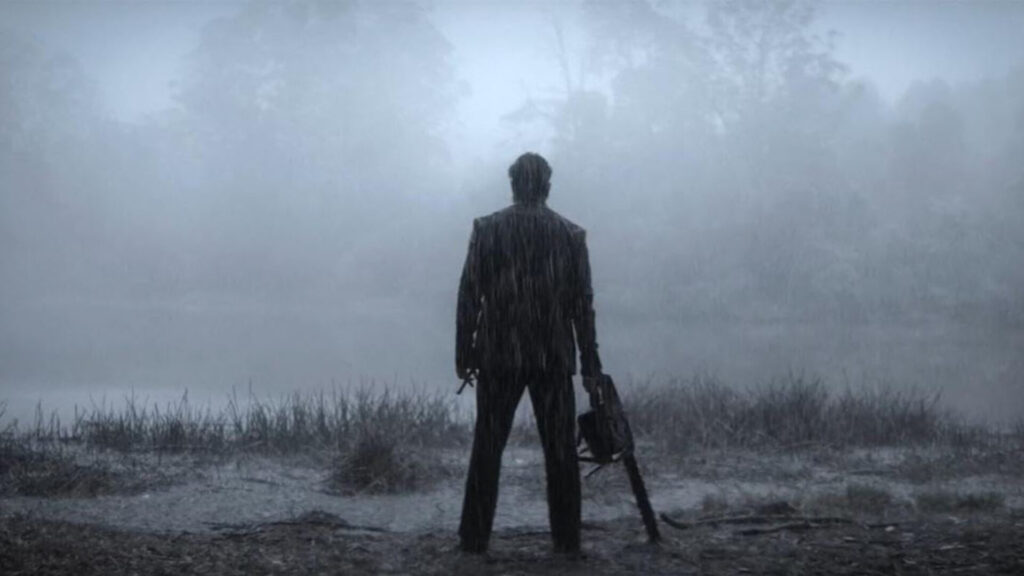 Das Bild zeigt Unni Mukundan in einer Szene des Films Marco. Er trägt eine kettensäge und es regnet.