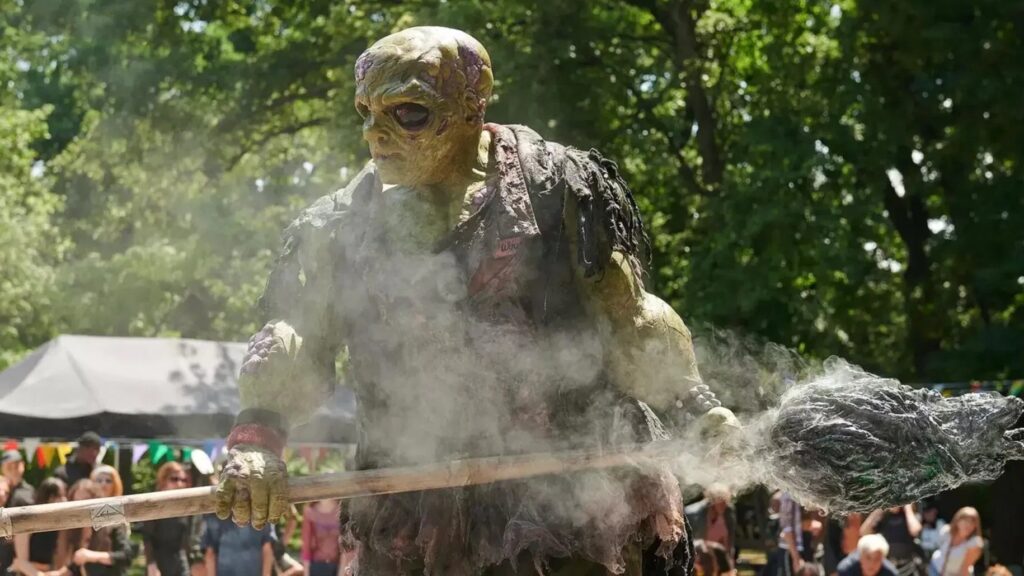 Der Toxic Avenger aus dem Film "The Toxic Avenger" hält einen Wischmopp