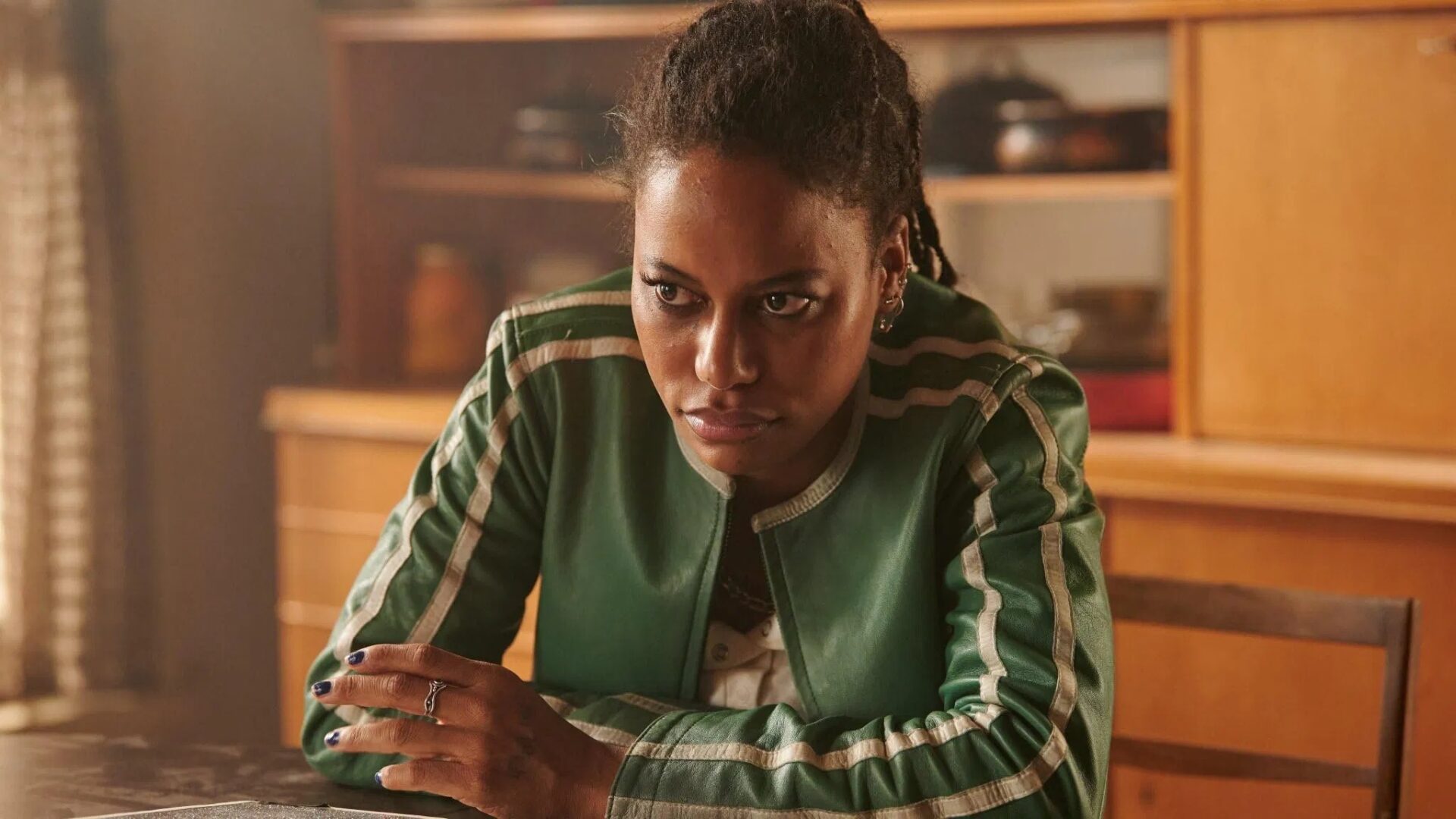 Taylour Paige im Film "The Toxic Avenger" sitzt an einem Tisch