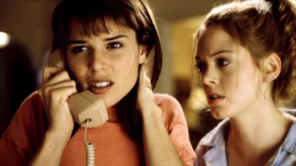 Sidney Prescott (Neve Campbell) telefoniert. Neben ihr steht eine weitere junge Frau.