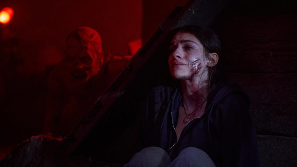 Das Bild zeigt eine verängstigte Frau die sich vor einem Monster versteckt | Top 5 Horror Videospiel Verfilmungen