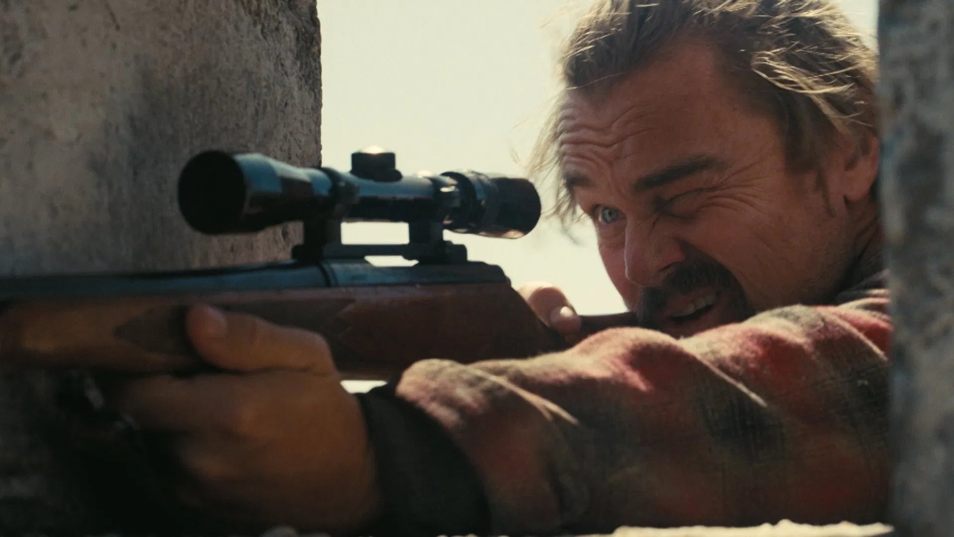 Das Bild zeigt Leonardo DiCaprio als Ghetto Pat mit einem Scharfschützengewehr im Film "One Battle After Another"