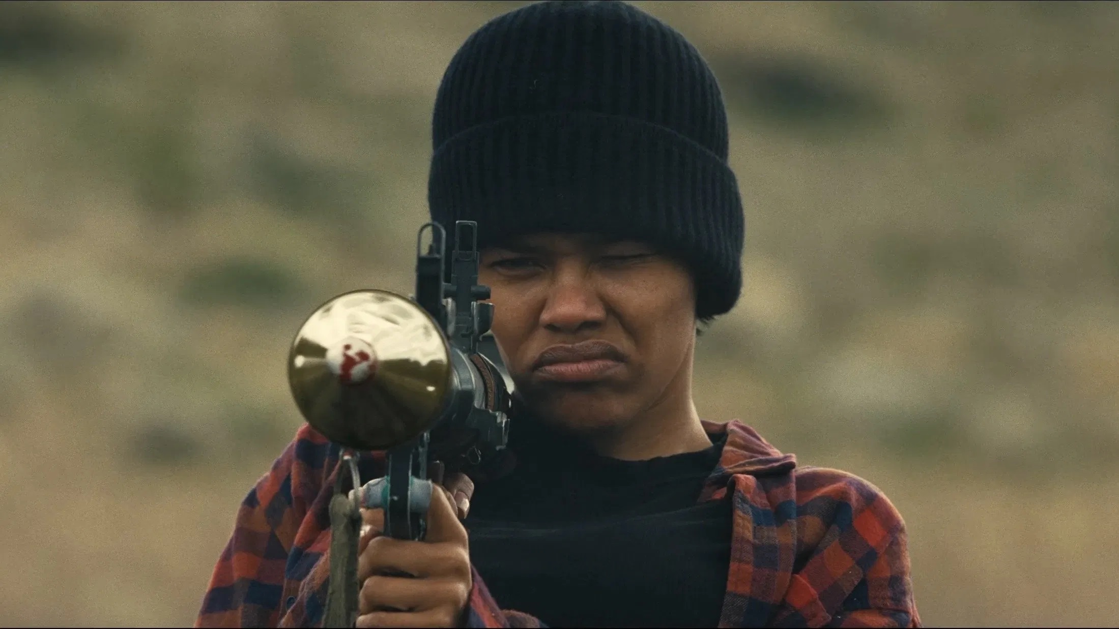 Das Bild zeigt die Perfidia Beverly Hills (gespielt von Teyana Taylor) schwer bewaffnet im Film "One Battle After Another"