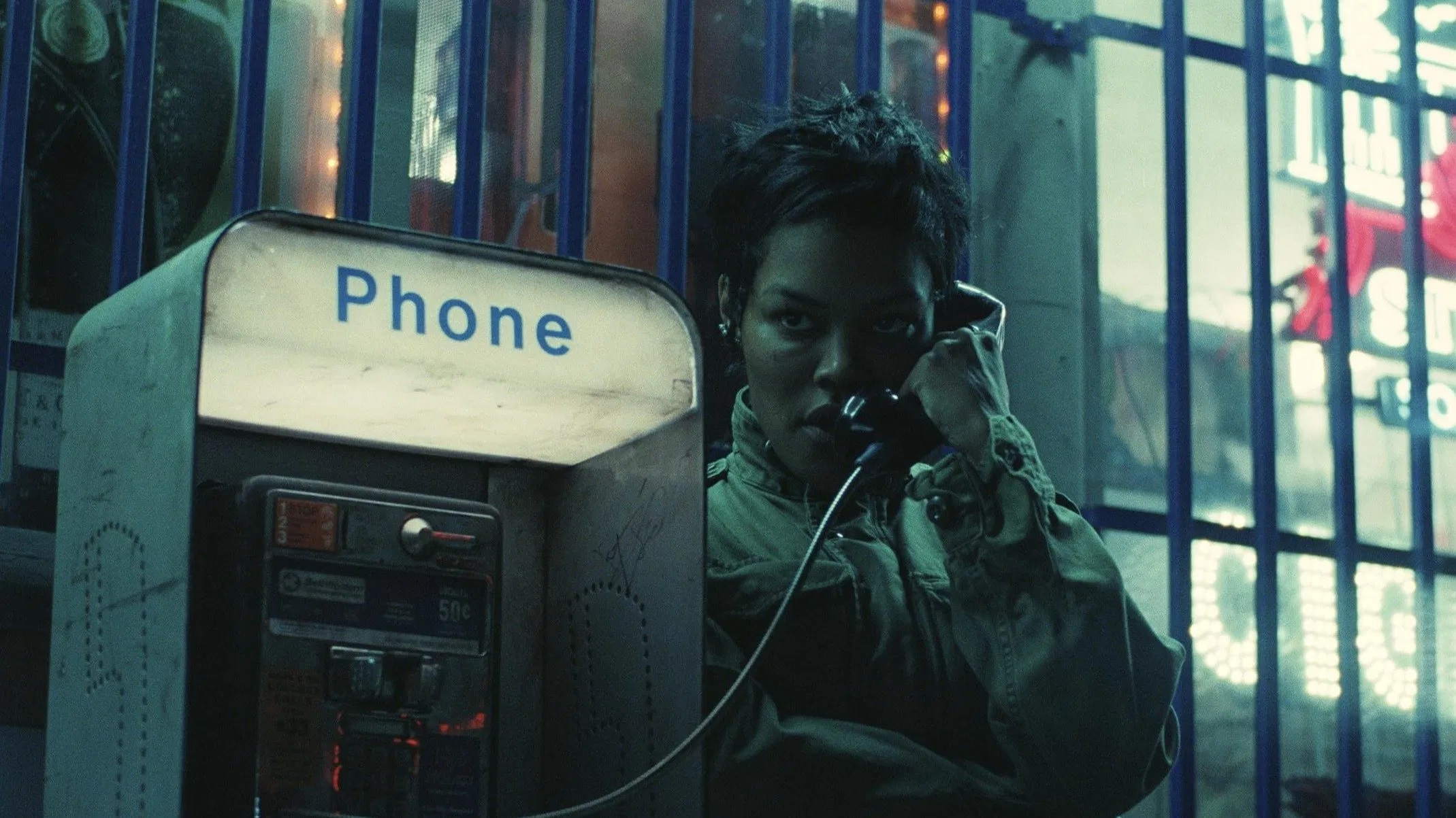 Das Bild zeigt die Aktivistin Perfidia Beverly Hills (gespielt von Teyana Taylor) an einem Münztelefon