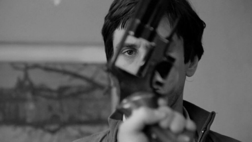 Das Bild zeigt Travis Bickle (Robert De Niro) aus "Taxi Driver" mit einer Waffe vor seinem Gesicht