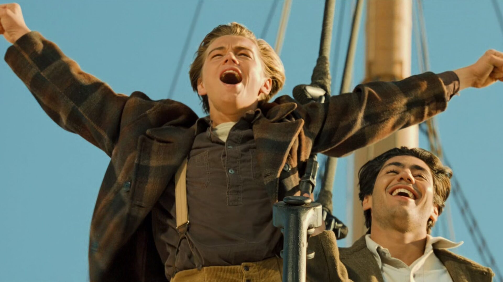 Das Bild zeigt Leonardo DiCaprio in seiner Rolle als Jack Dawson, die arme jubelnd ausgestreckt, im Film "Titanic"