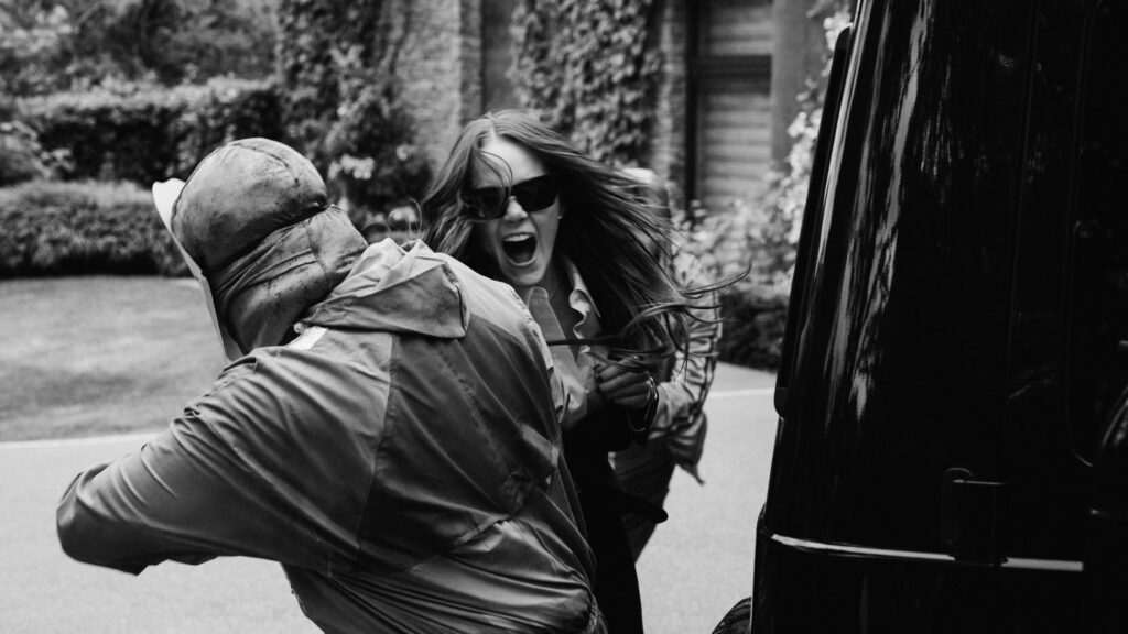 Das Bild zeigt Emma Stone in einem Kampf mit einer maskierten Person in einer Szene des Films Bugonia