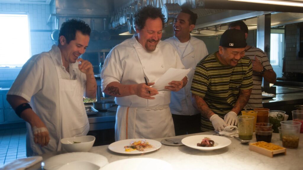 Jon Favreau im Film "Kiss the Cook" steht mit seinem Team in der Küche und bespricht das Menü