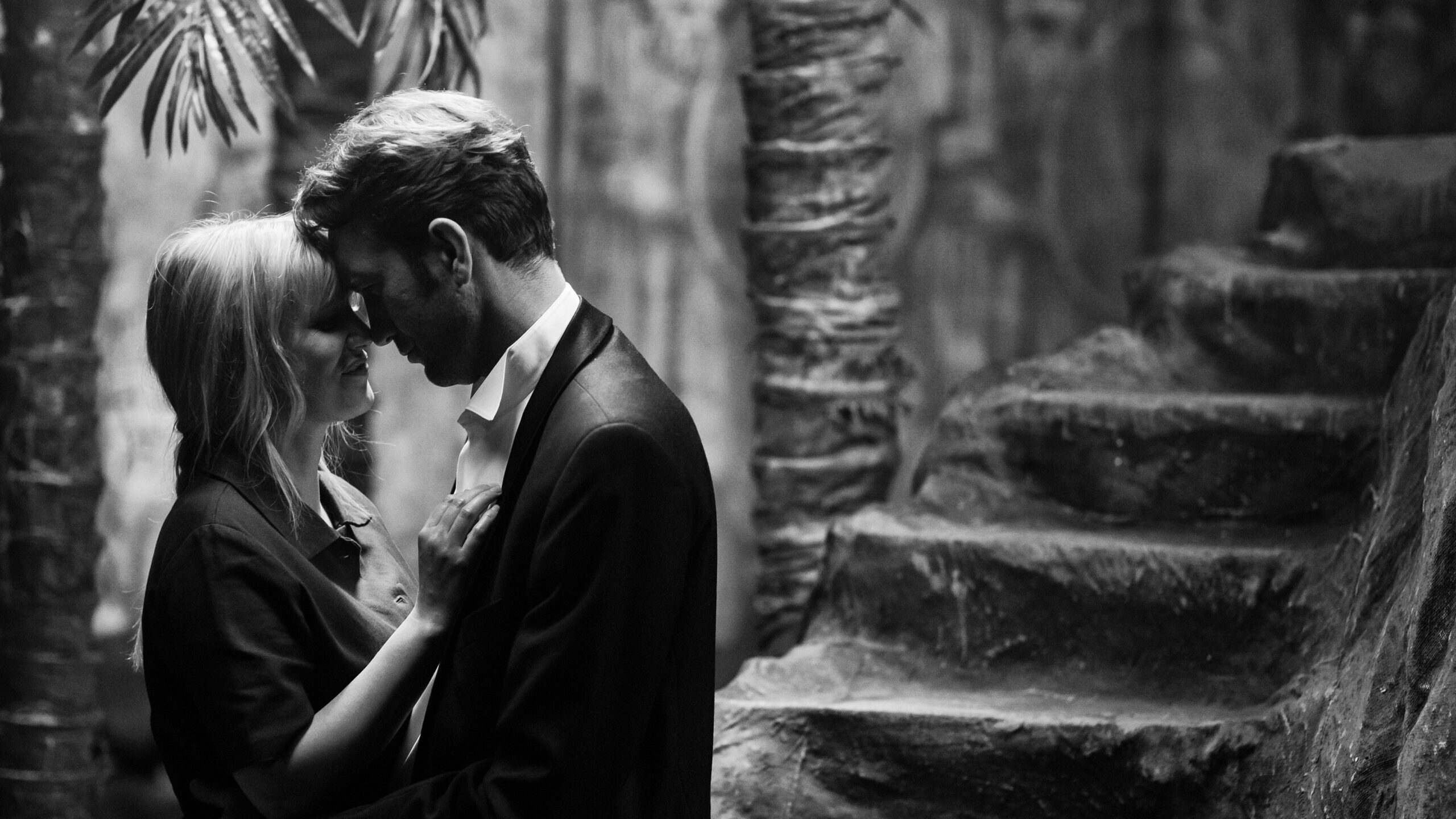 Zula und Wiktor in inniger Umarmung. Im Hintergrund Palmen.