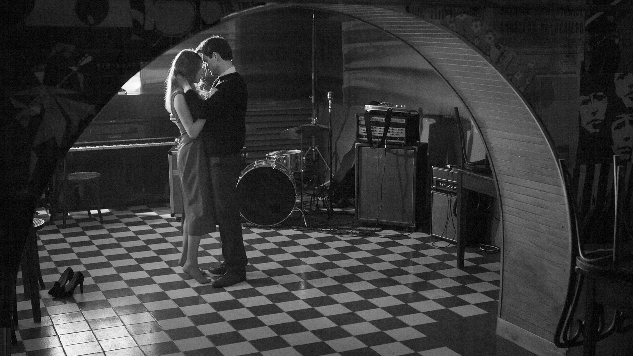 Ein Mann und eine Frau tanzen in inniger Umarmung in einer Kellerbar.