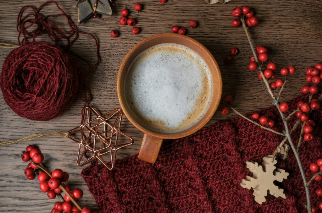 Das Bild zeigt eine Kaffeetasse mit Kaffee und Milchschaum in einem herbstlichen Ambiente | Media Monday #753