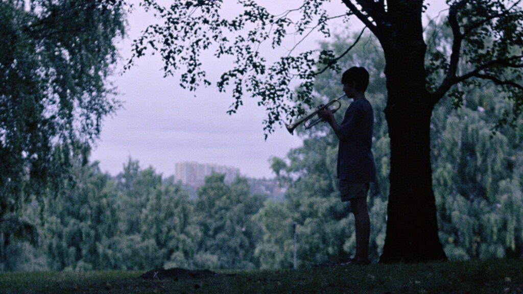 Das Bild zeigt einen Jungen mit einer Trompete in einer Szene des Films "Handling the Undead". Einer der 5 besten Geheimtipps 2025