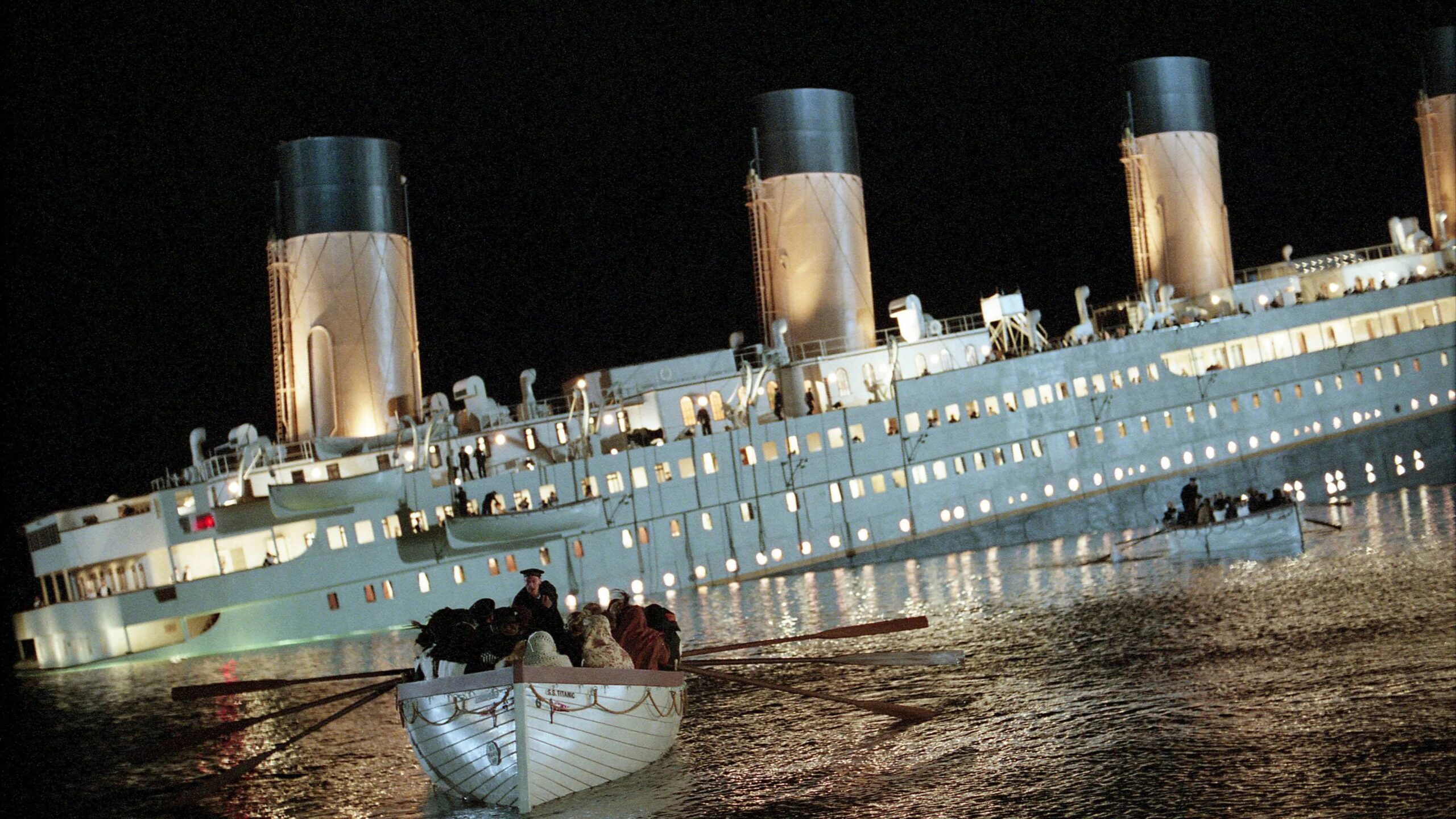 Das Bild zeigt wie die Titanic stetig sinkt. Vor ihr treiben Rettungsboote im Wasser