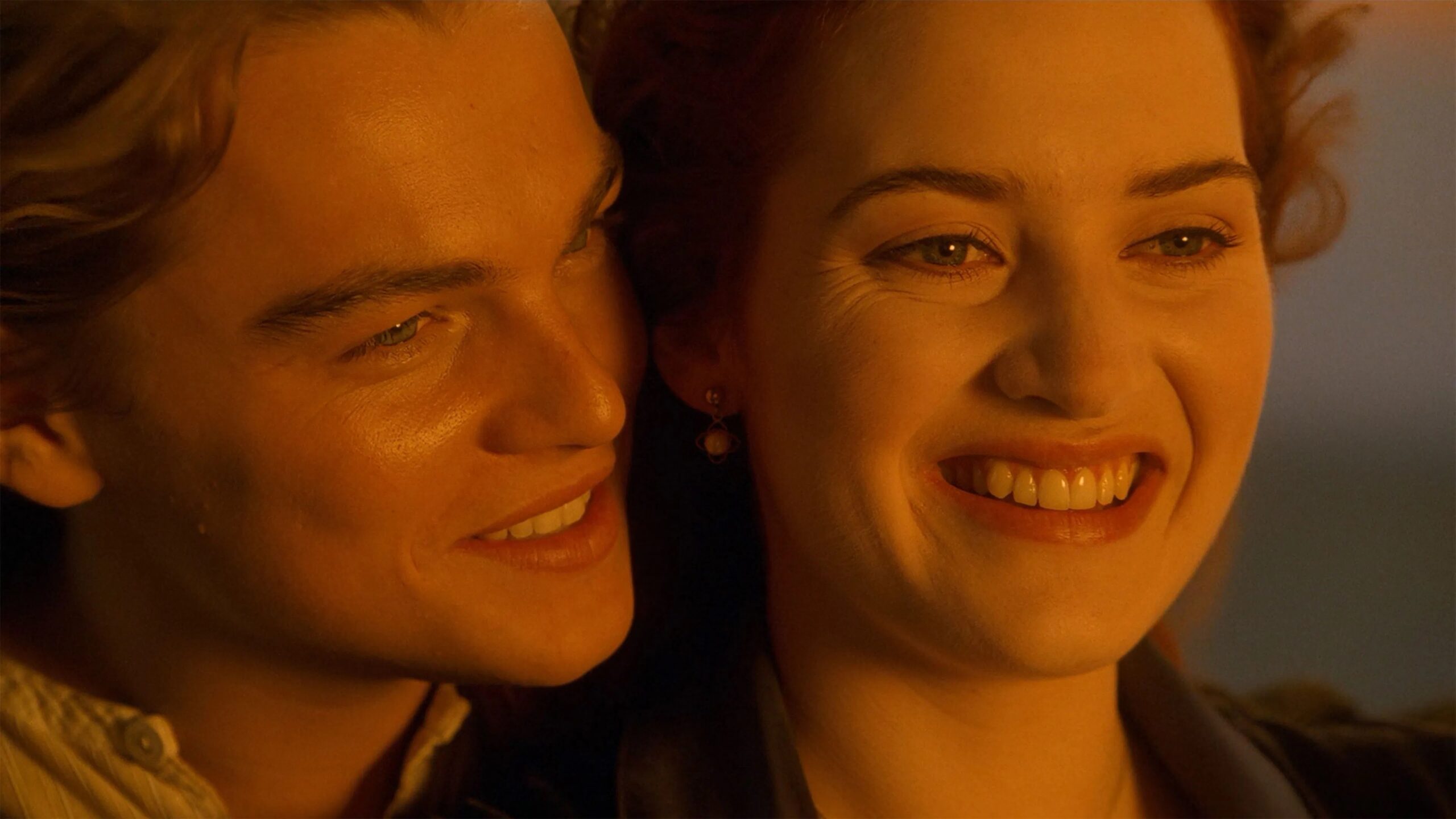Das Bild zeigt Jack (Leonardo DiCaprio) und Rose (Kate Winslet) lächelnd im Sonnenuntergang