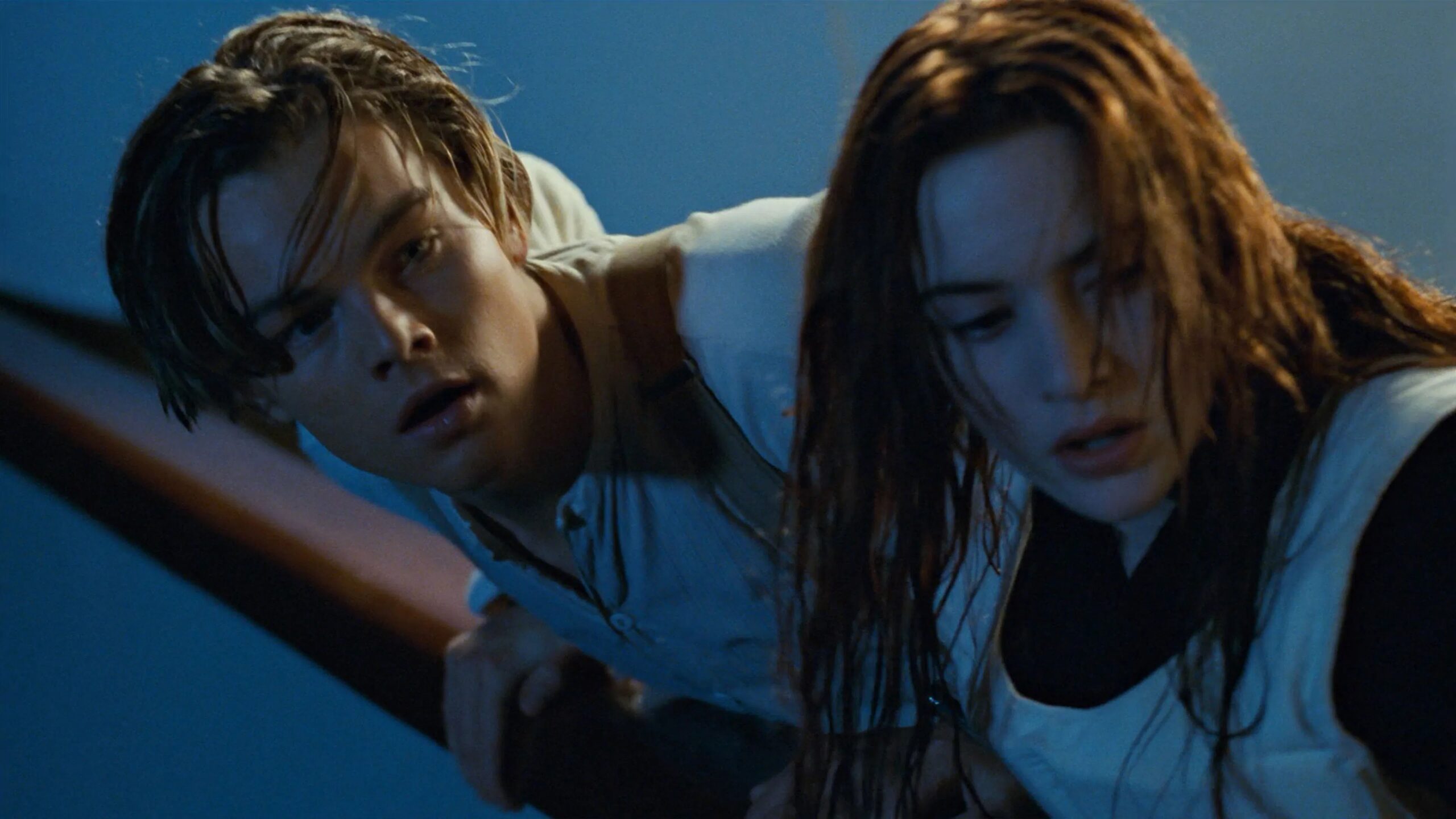 Das Bild zeigt Jack (Leonardo DiCaprio) und Rose (Kate Winslet) am Deck der Titanic. Beide schauen über die Reling. Sie trägt eine Schwimmweste