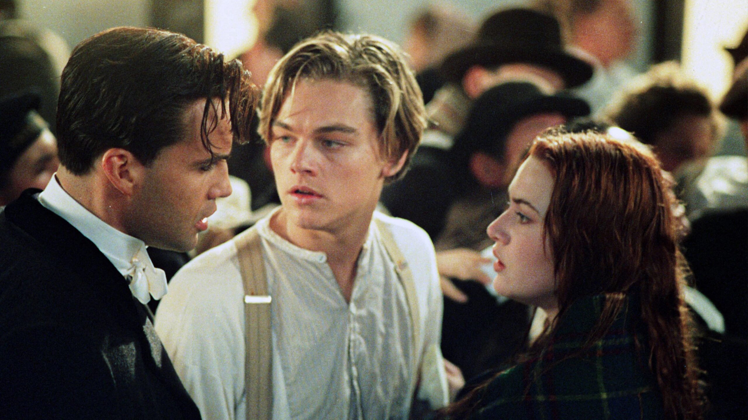 Das Bild zeigt Rose DeWitt Bukater (Kate Winslet), Jack Dawson (Leonardo DiCaprio, Mitte) und Caledon „Cal“ Hockley (Billy Zane) am Deck der Titanic während des Untergangs