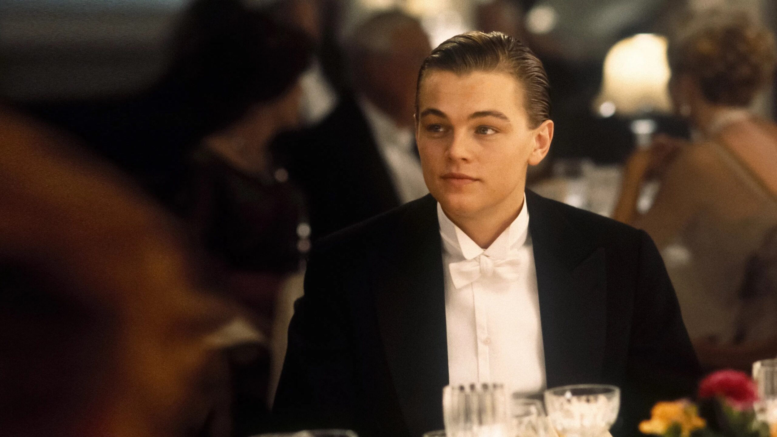 Das Bild zeigt Jack Dawson (Leonardo DiCaprio) elegant gekleidet in einer Dinner Szene