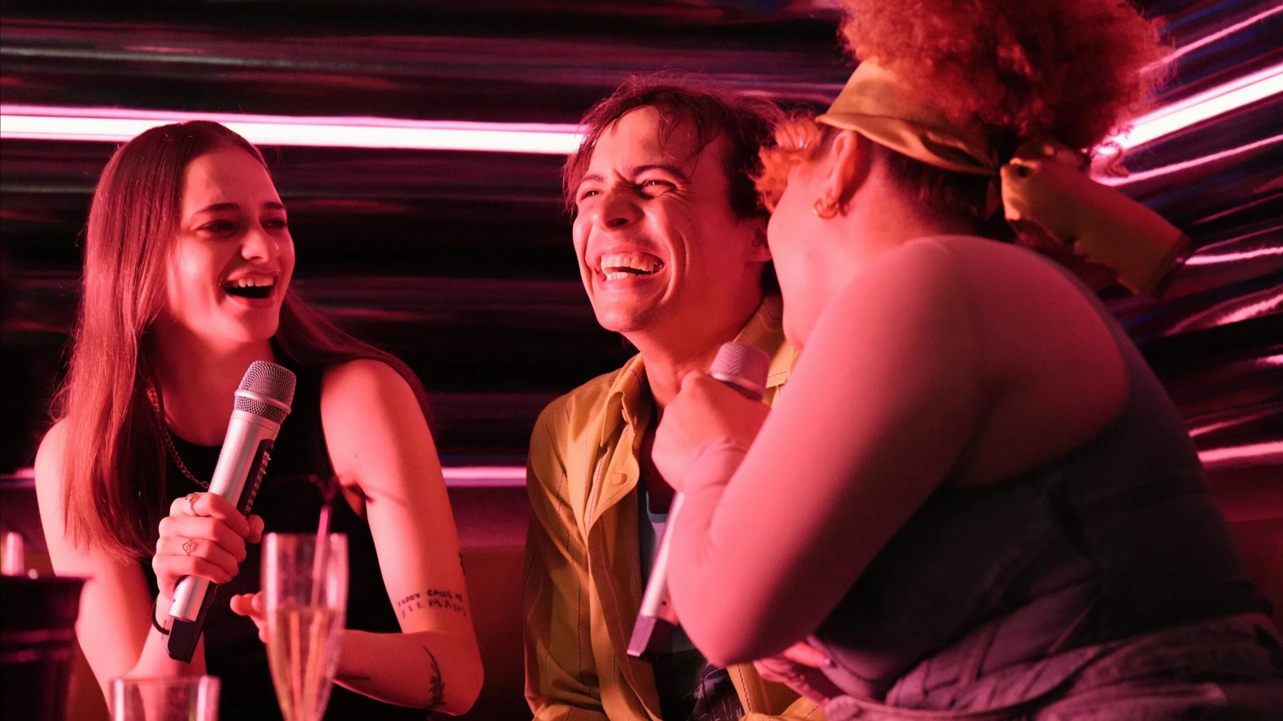 Das Bild zeigt Mike (Frank Dillane) und seine beiden Kolleginnen ausgelassen in einer Karaoke Bar