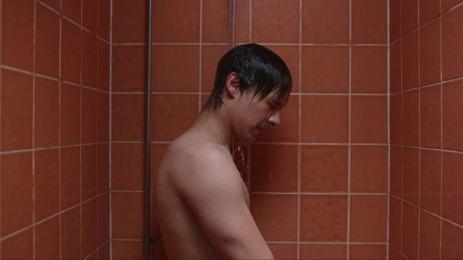 Das Bild zeigt Mike (Frank Dillane) in einer orange gekachelten Dusche in dem Film "Urchin"