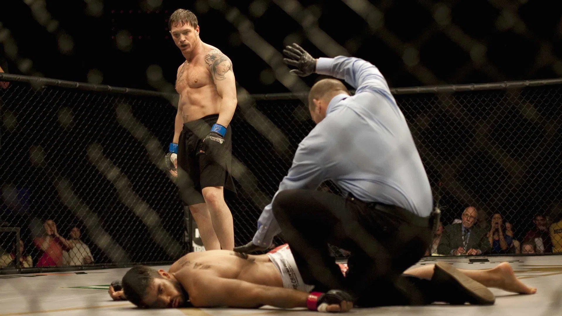 Tom Hardy im Film "Warrior" steht über seinem besiegten Gegner im Octagon  | Die 5 besten Box- und Kampfsportfilme