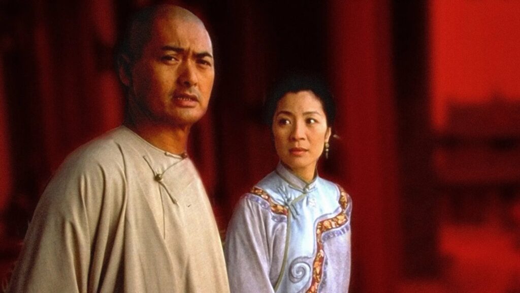 Chow Yun-Fat im Film "Tiger & Dragon" schaut in die Kamera, hinter ihm steht Michelle Yeoh und schaut ihn an. | Die 5 besten asiatischen Actionstars