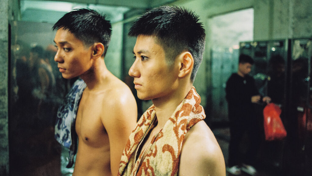 Das Bild zegt Nam (Phạm Thanh Hải) und Viet (Đào Duy Bảo Định) vor dem Spiegel im Umkleideraum des Bergwerks im Film Viet und Nam