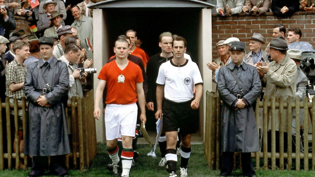 Das Bild zeigt die deutsche und die ungarische Nationalmannschaft beim Einlaufen im Stadion in einer Szene des Films Das Wunder von Bern. Einer der 5 besten Fußball-Filme.