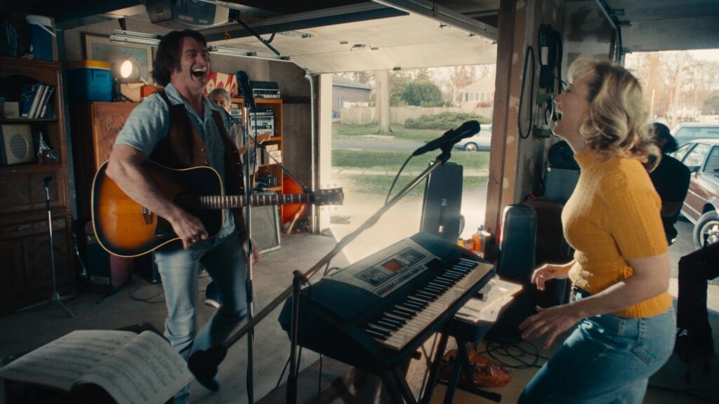 Hugh Jackman und Kate Hudson im Film "Song Sung Blue" stehen in einer Garage mit Gitarre und Keybord und singen gemeinsam | Die 5 besten Musik-Biopics