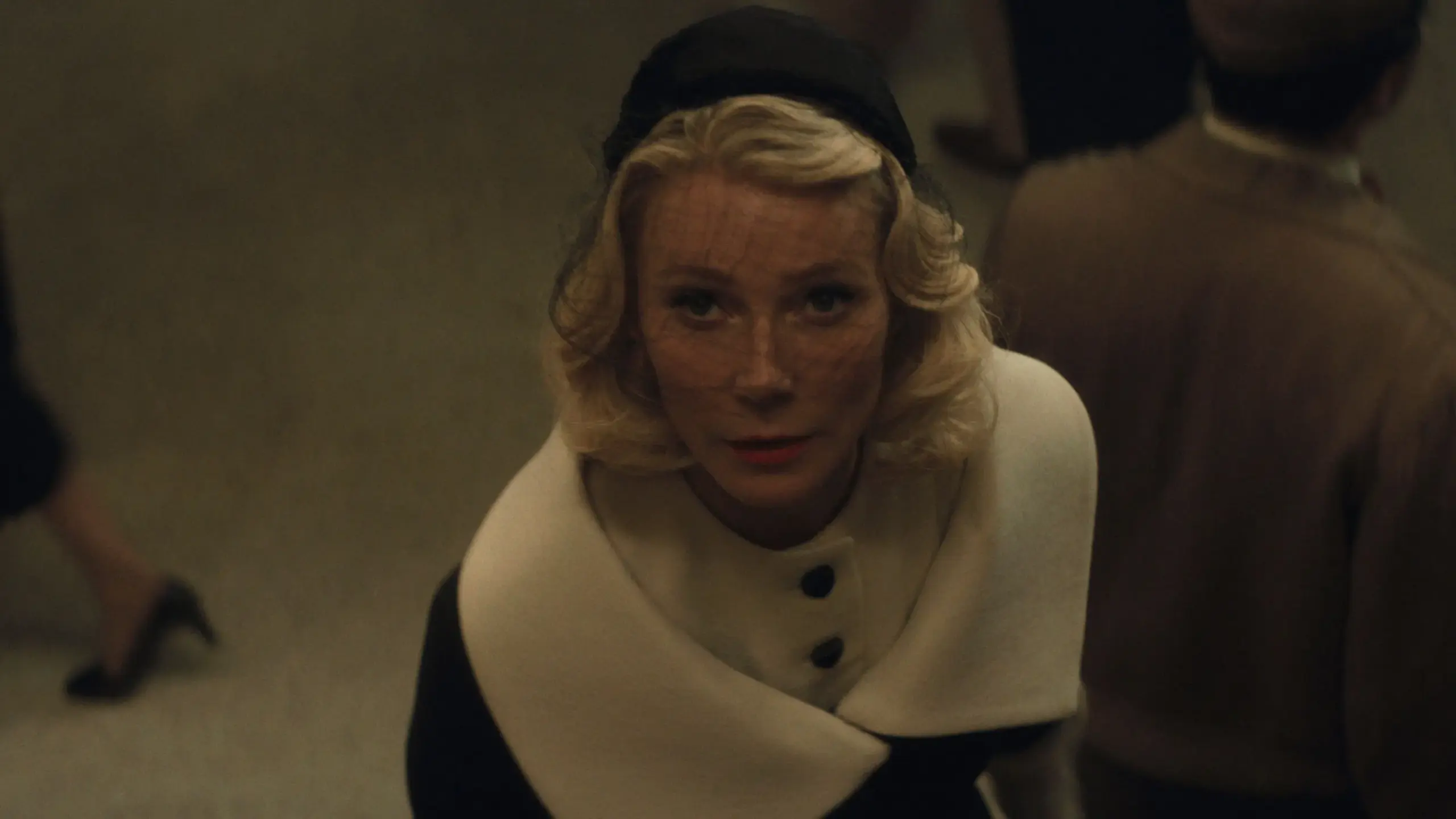 Das Bild zeigt eine Frau mit einem Schleier vor dem Gesicht die nach oben schaut.