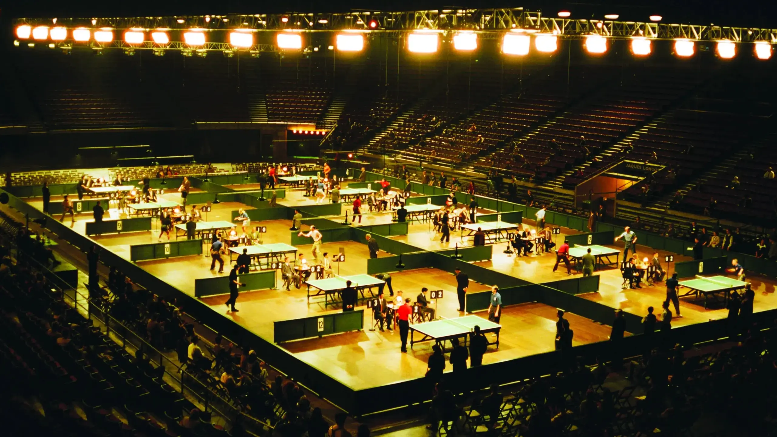 Das Bild Zeigt eine Arena gefüllt mit Tischtennisplatten während eines Tuniers. | Marty Supreme