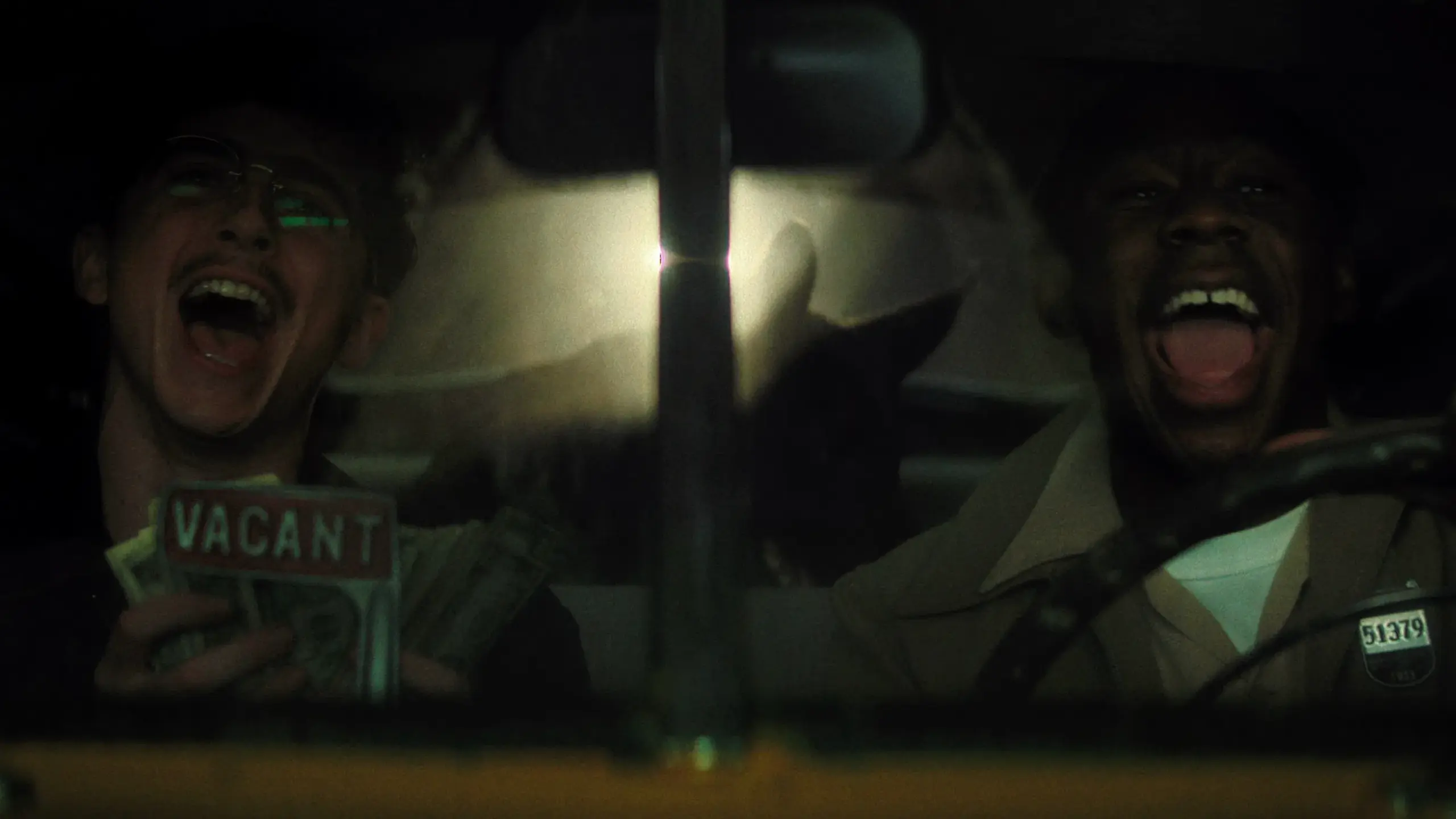 Das bild zeigt zwei Freunde lachend auf den Vordersitzen eines Taxis.