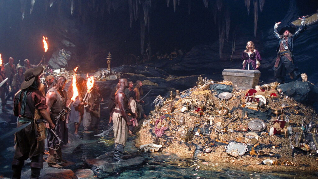 Links stehen Piraten mit Fackeln, rechts steht eine Frau und ein Mann auf einem Berg aus Schätzen. | Die 5 besten Filme mit Piraten