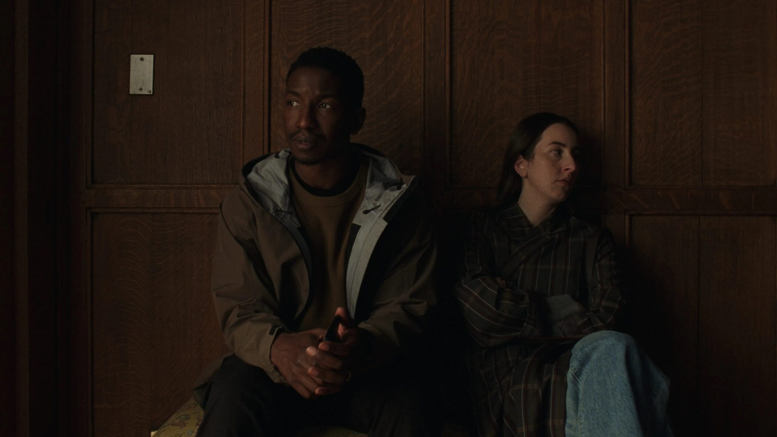 Das Bild zeigt Rachel (Alana Haim, rechts) und Mike (Mamoudou Athie) vor einer vertäfelten Wand, sichtlich nachdenklich und emotional aufgerüttelt