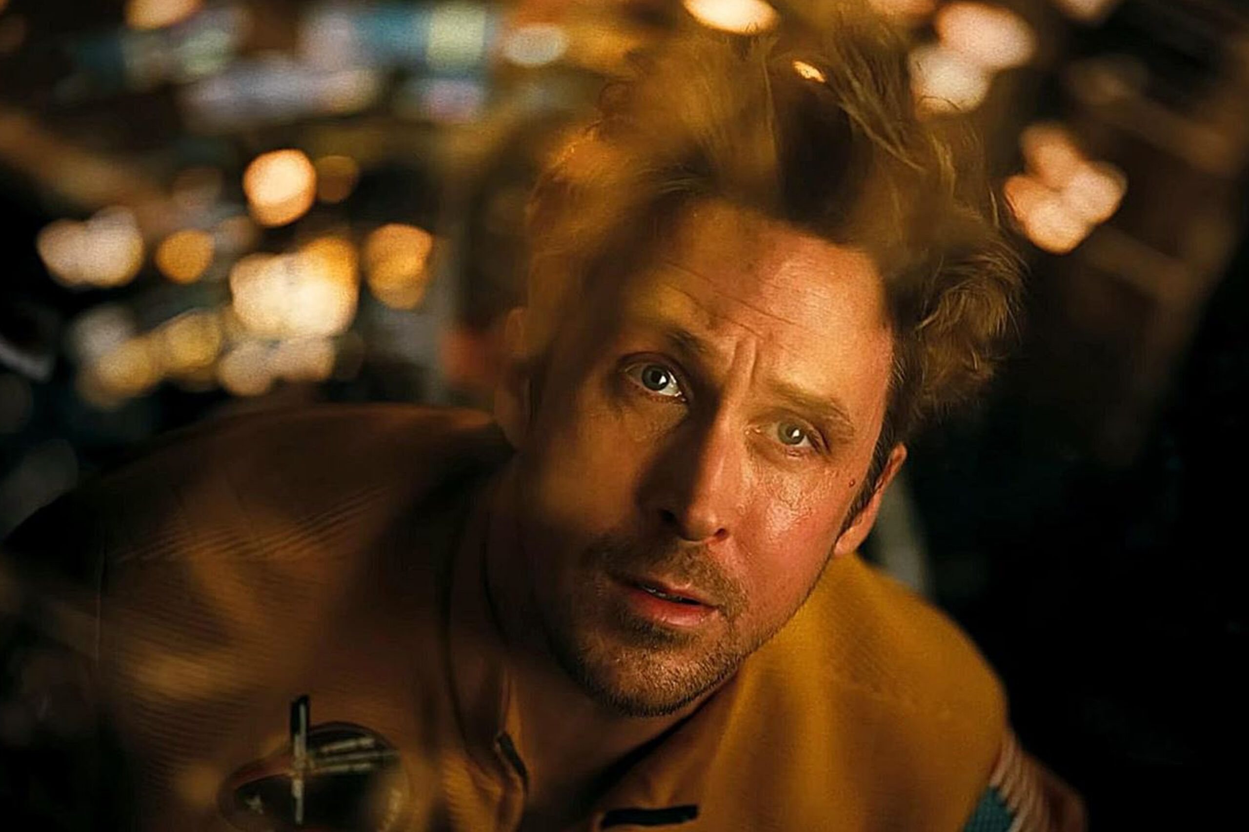 Das Bild zeigt Ryland Grace (Ryan Gosling), der durch die Scheibe ins Weltall starrt. Sein Blick ist staunend und ängstlich zugleich