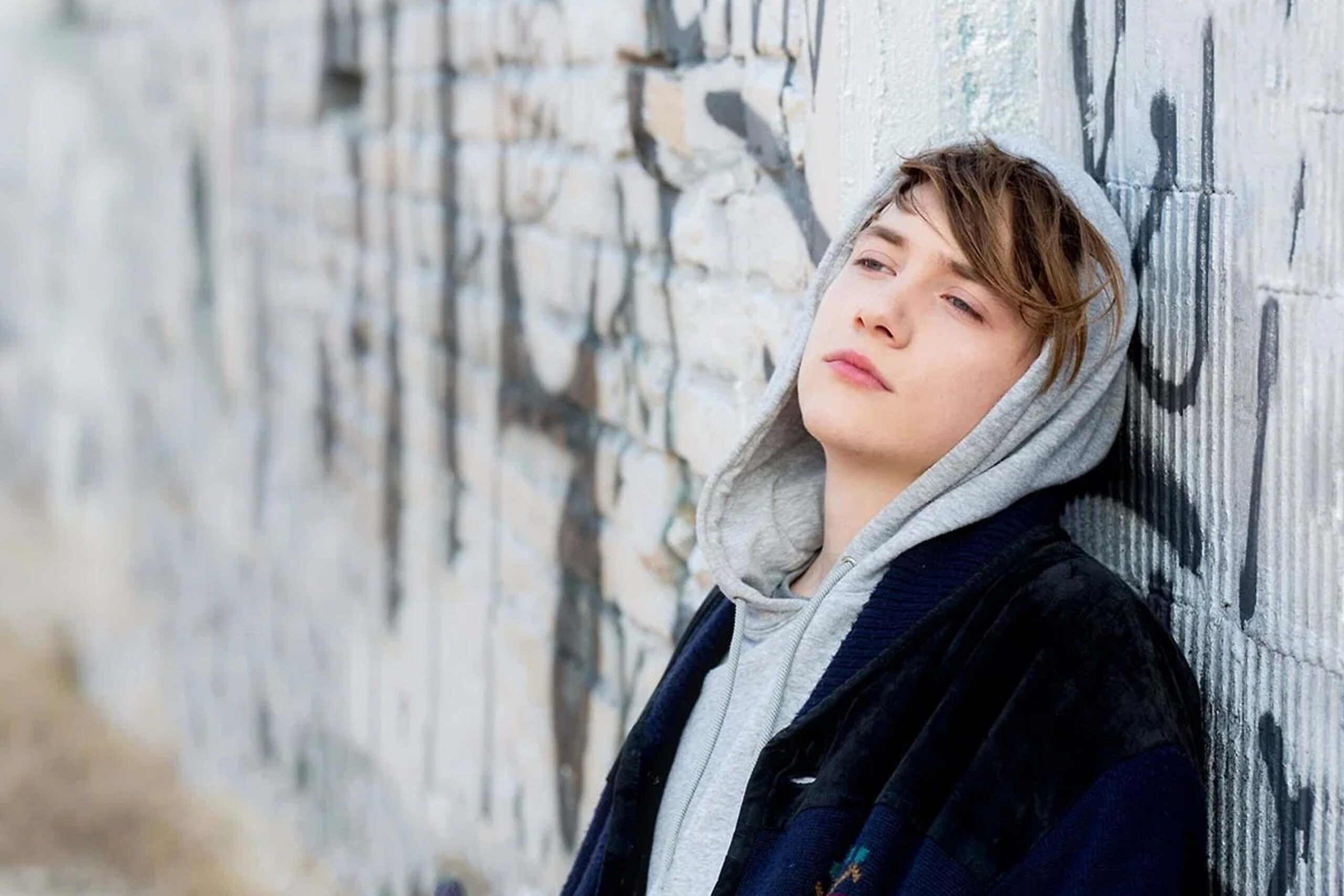 Matteo Florenzi, gespielt von Michelangelo Fortuzzi in der Serie DRUCK, lehnt in urbaner Umgebung vor einer graffiti­bedeckten Wand. | Media Monday #774