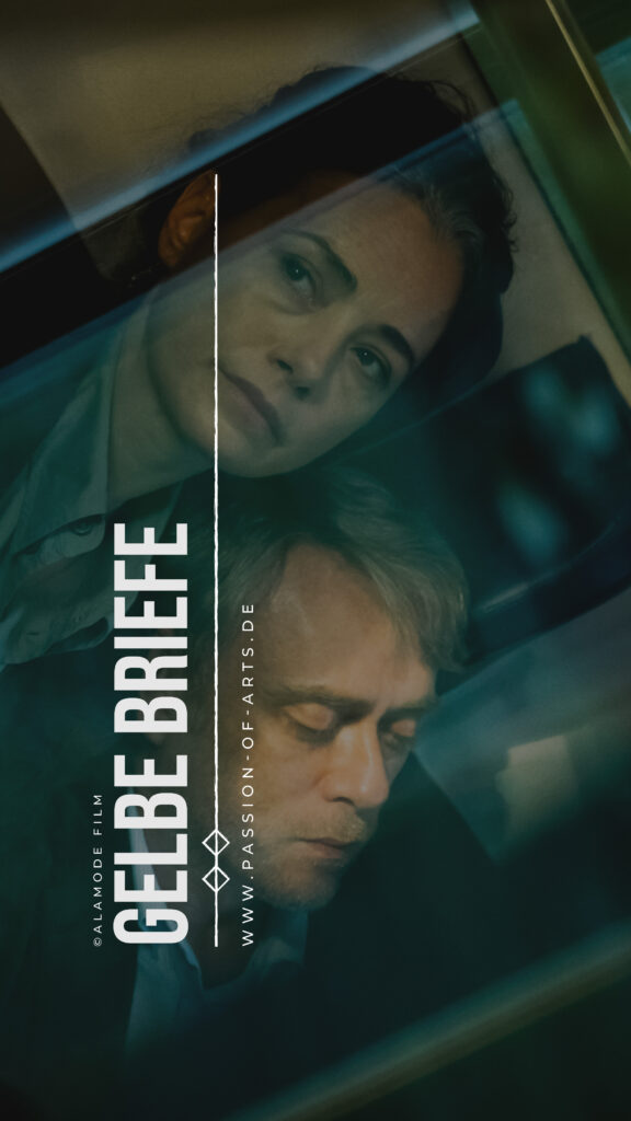 Stimmungsvolles Filmplakat zu ‚Gelbe Briefe‘ mit zwei nachdenklichen Personen hinter einer spiegelnden Fensterscheibe; dunkle, melancholische Lichtstimmung und der Titel des Films im unteren Bereich.