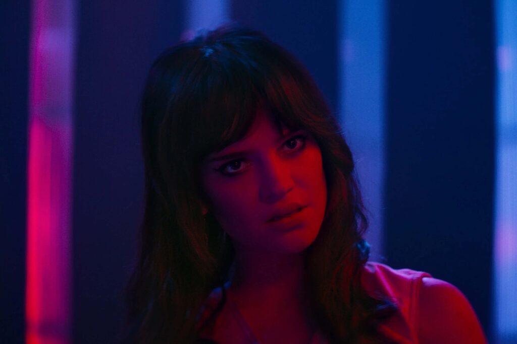 Sophie Thatcher in Her Private Hell, intensiv beleuchtet in roten und blauen Neonfarben vor futuristischem Hintergrund. | Media Monday #774
