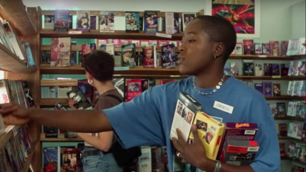 Cheryl sortiert in einem Videokassettenleihgeschäft VHS-Kassetten ein. Im Hintergrund ist Diana zu sehen, welche gerade nach einem Film sucht. | The Watermelon Woman Filmkritik