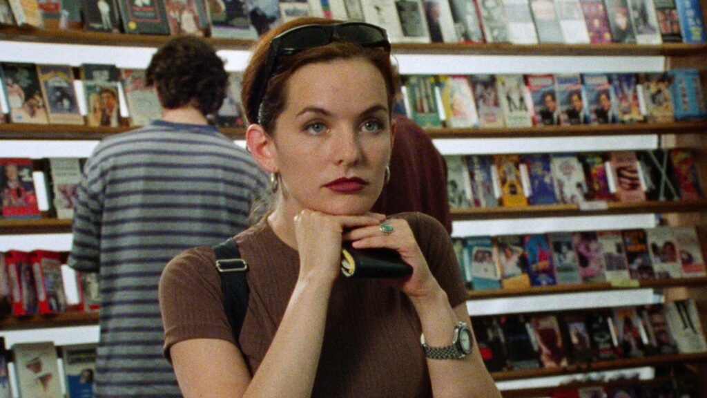 Diana steht in einem Videokassettenleihgeschäft und wartet mit ihrer Brieftasche in der Hand an der Kasse. | The Watermelon Woman Filmkritik
