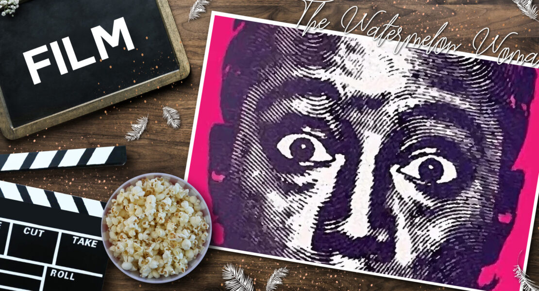 Filmklappe, Popcorn und pink‑violettes Poster zu „The Watermelon Woman“ auf Holzoberfläche, dekoriert mit weißen Federn – cineastische Still‑Life‑Szene mit Fokus auf klassischem Filmequipment und ikonischem Poster.