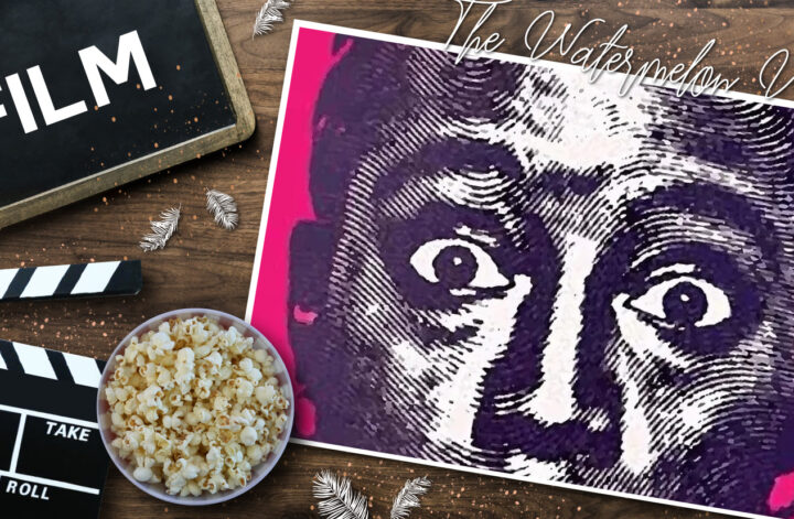 Filmklappe, Popcorn und pink‑violettes Poster zu „The Watermelon Woman“ auf Holzoberfläche, dekoriert mit weißen Federn – cineastische Still‑Life‑Szene mit Fokus auf klassischem Filmequipment und ikonischem Poster.
