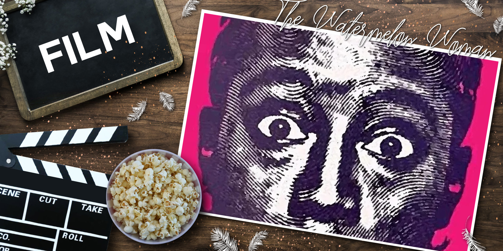 Filmklappe, Popcorn und pink‑violettes Poster zu „The Watermelon Woman“ auf Holzoberfläche, dekoriert mit weißen Federn – cineastische Still‑Life‑Szene mit Fokus auf klassischem Filmequipment und ikonischem Poster.